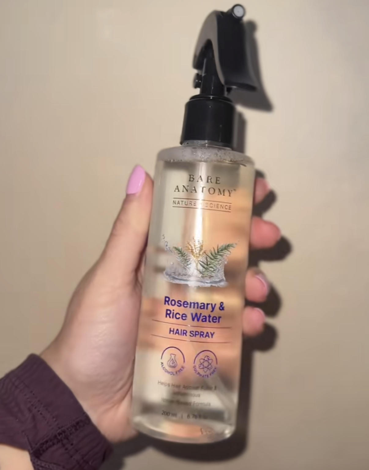 Priya N. holding her Rosemary Mist hair spray